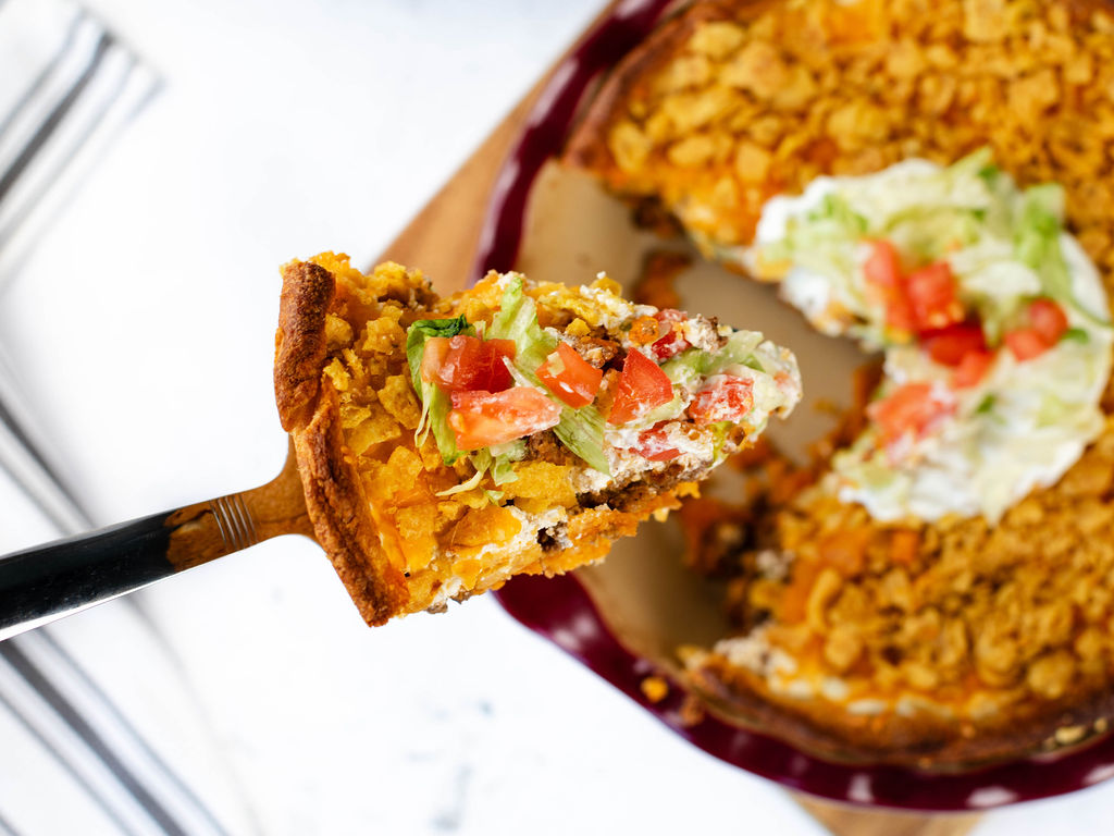 a slice of Frito taco pie on a serving spoon.