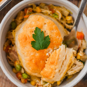 an up close look at biscuits in a bowl with creamy chicken and gravy.