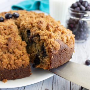 a slice of banana cake with blueberries ready to serve.
