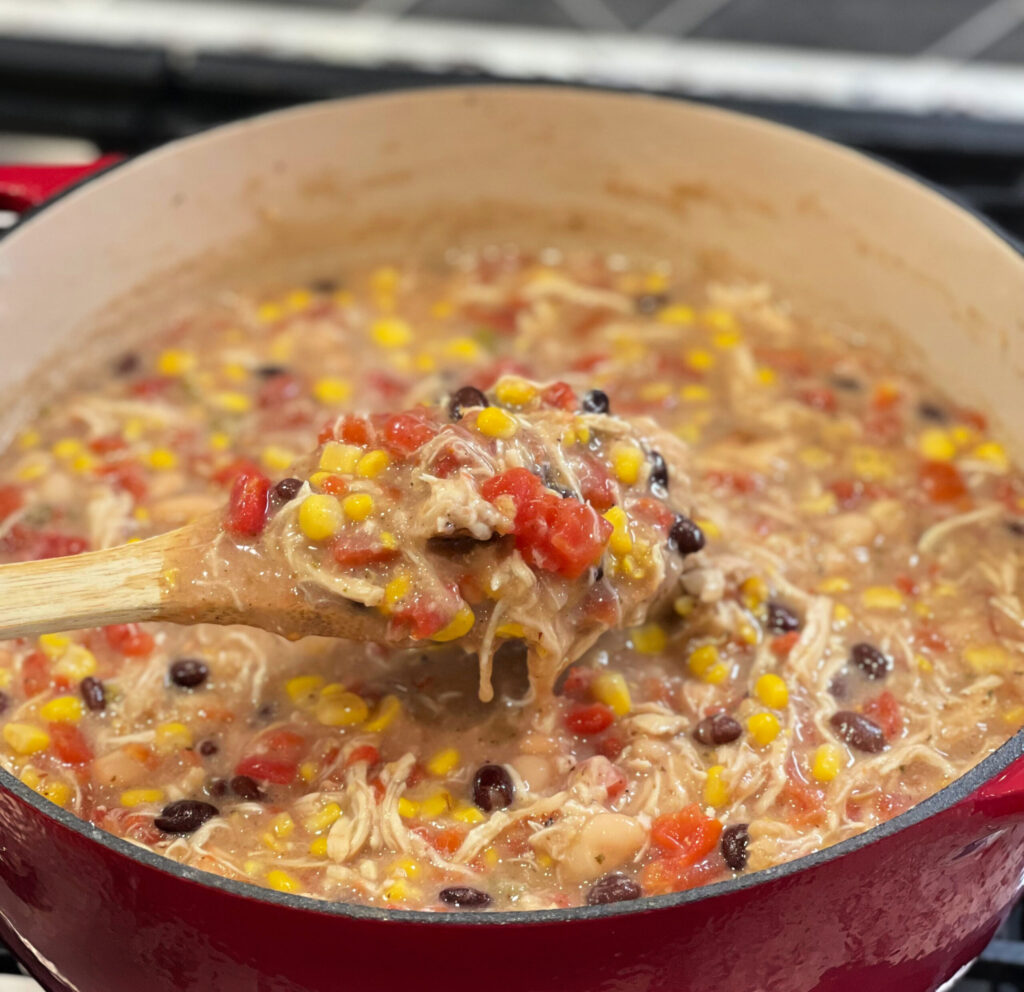 shredded chicken, beans, corn, and tomatoes combined in a dutch oven