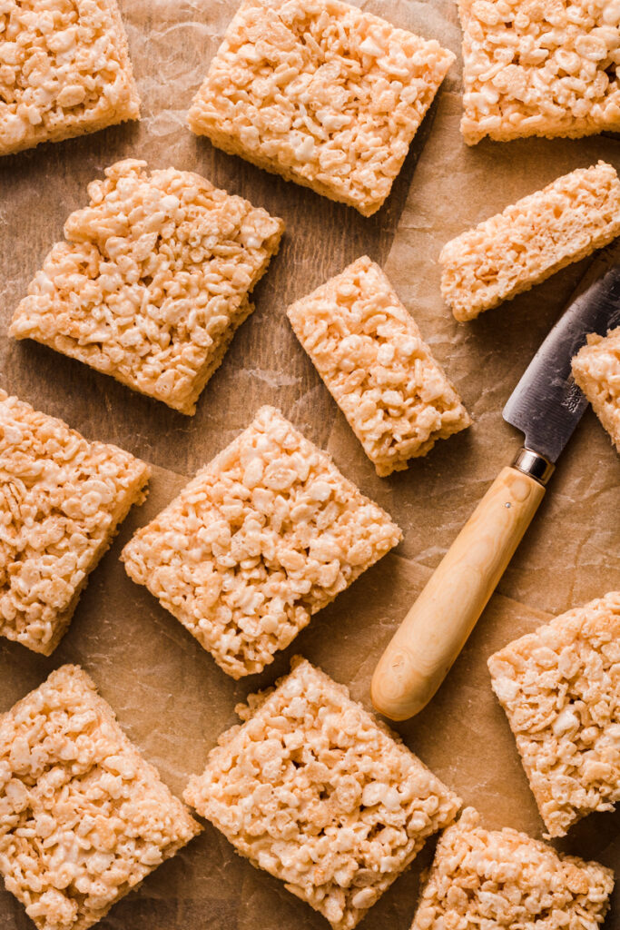 a batch of cut rice krispies treats on parchment paper