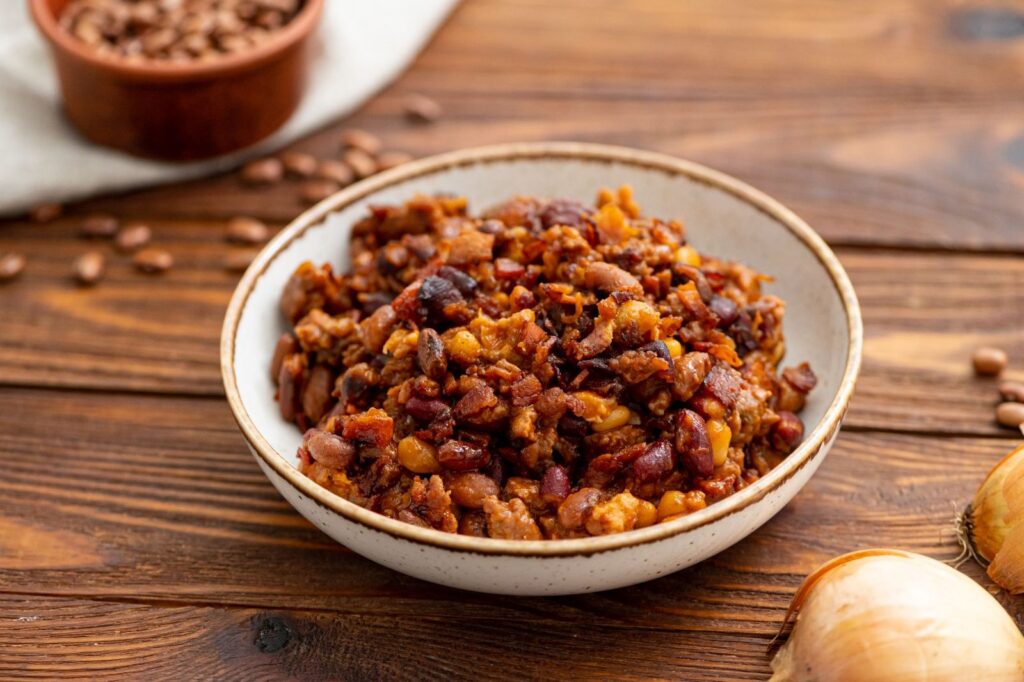 beef, bacon, and beans combined into a cowboy beans dish