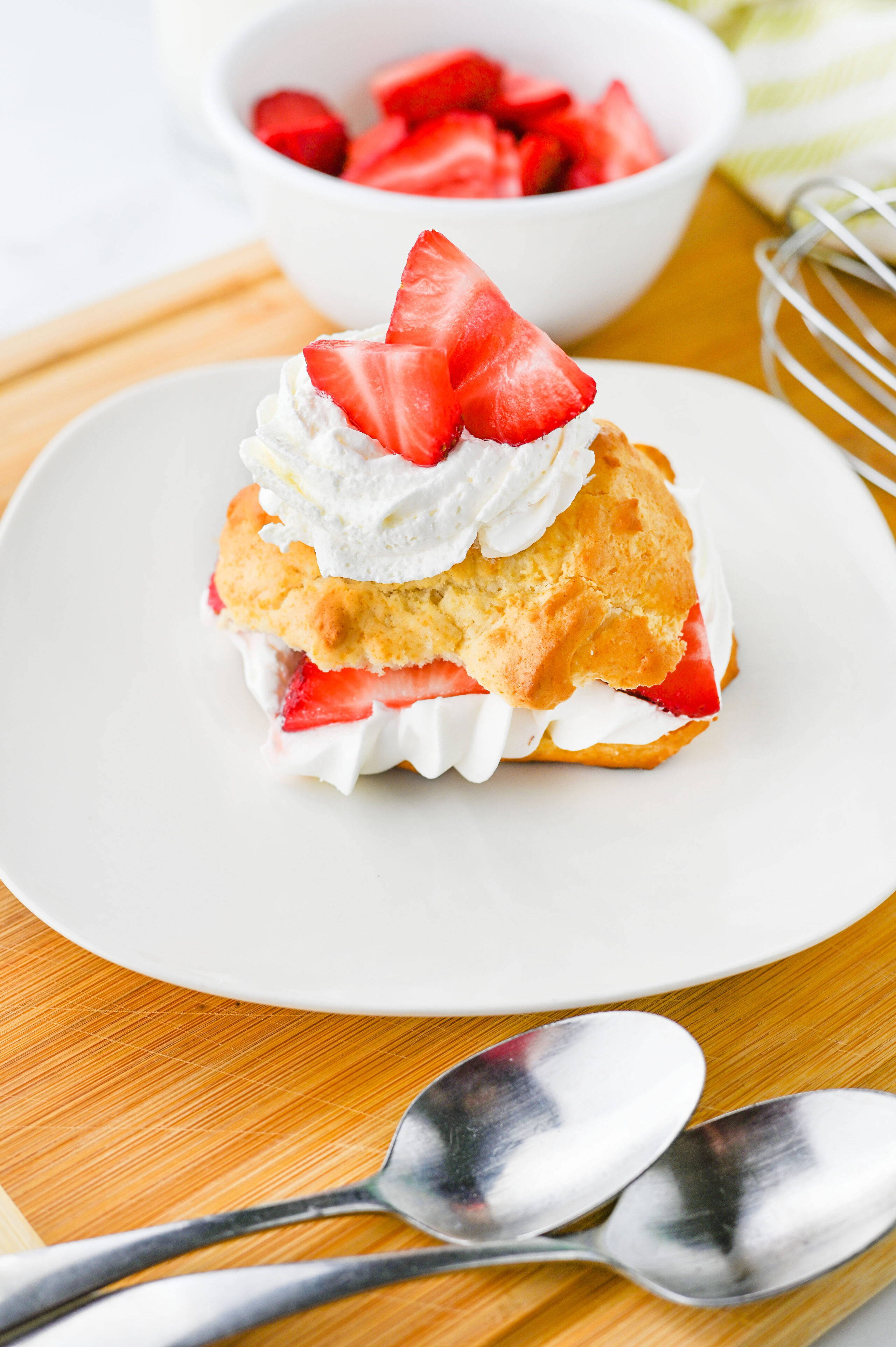 a strawberry shortcake with whipped cream on a white plate.