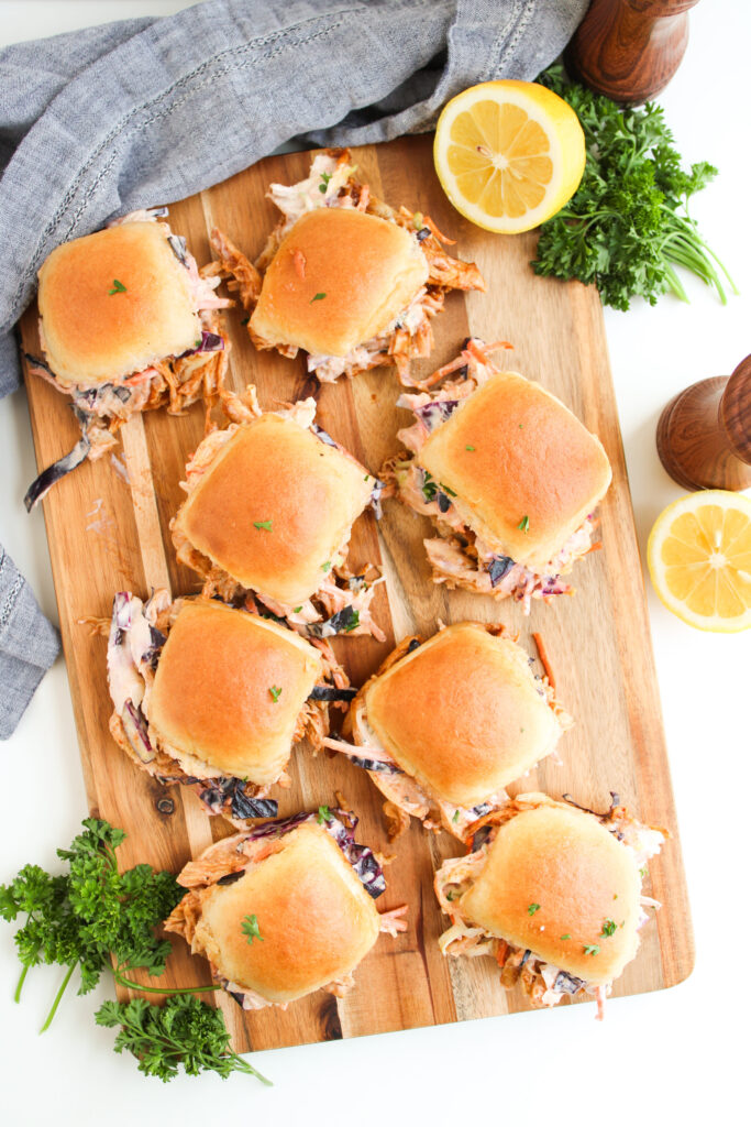 sliders assembled on a wood cutting board.