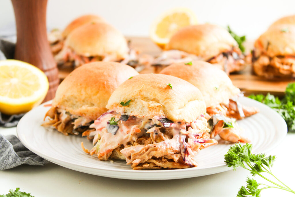 a BBQ coated chicken slider medley on a white plate.