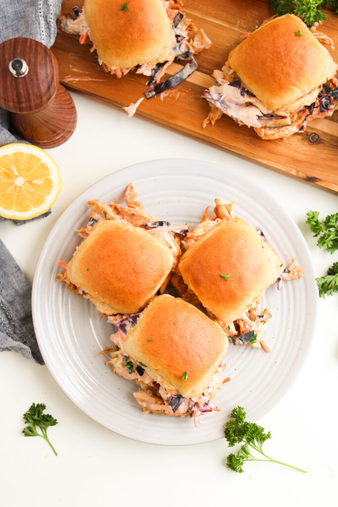 mini sandwiches with a homemade slaw served on a white plate.