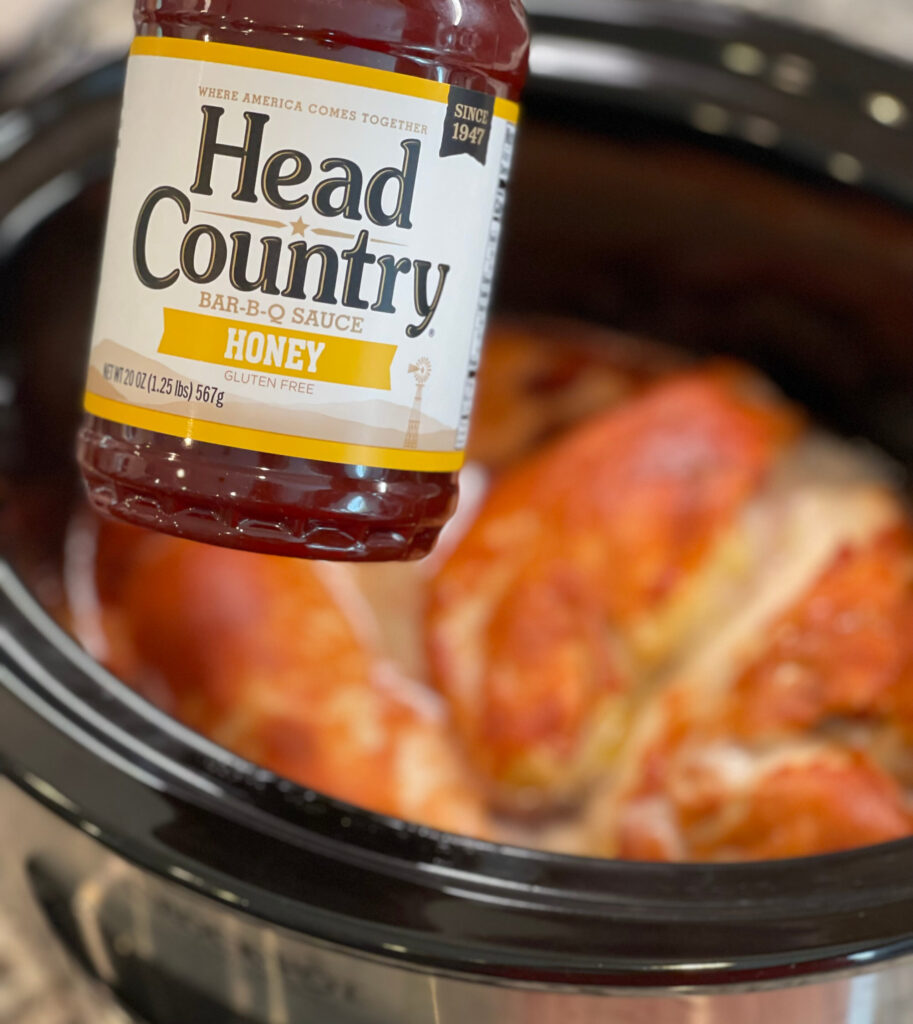 bbq sauce poured on top of crockpot chicken