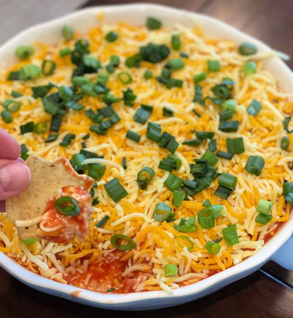tortilla chips scooped into layered mexican dip