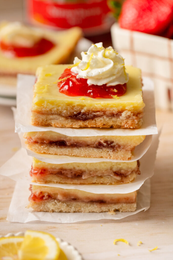 a stack of Strawberry Lemon Bars on parchment paper.