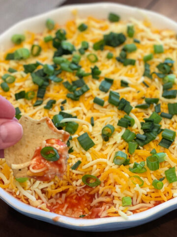 tortilla chips scooped into layered mexican dip