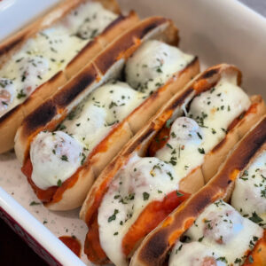 meatballs in a sandwich with pasta sauce and provolone cheese on top