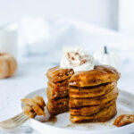 a stack of pumpkin pie spice pancakes on a plate.