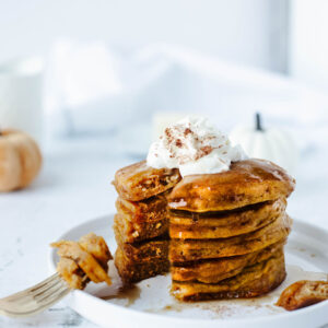 a stack of pumpkin pie spice pancakes on a plate.