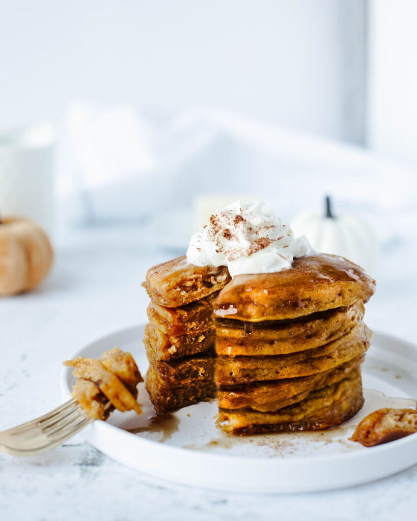 a stack of pumpkin pie spice pancakes on a plate.