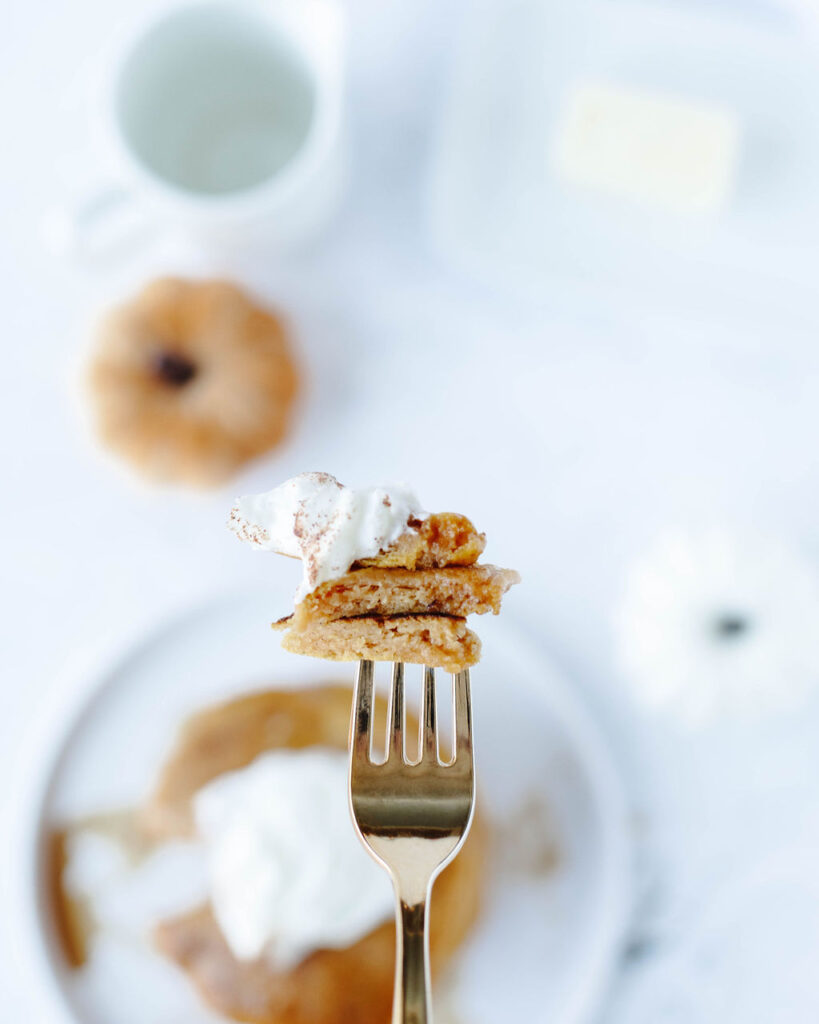 a fork with a bite of pumpkin pancakes ready to eat.