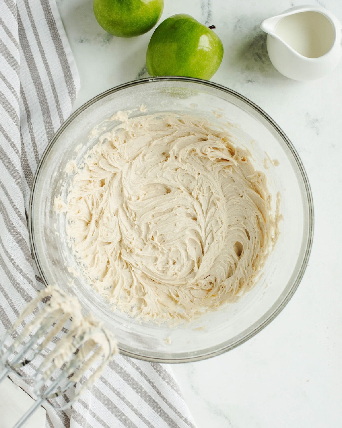 an apple bread batter combined in a glass mixing bowl.