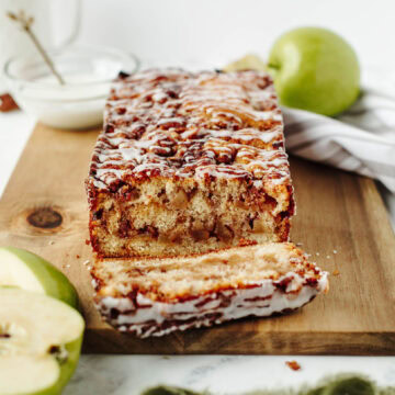 sliced apple fritter bread on a wood cutting board.