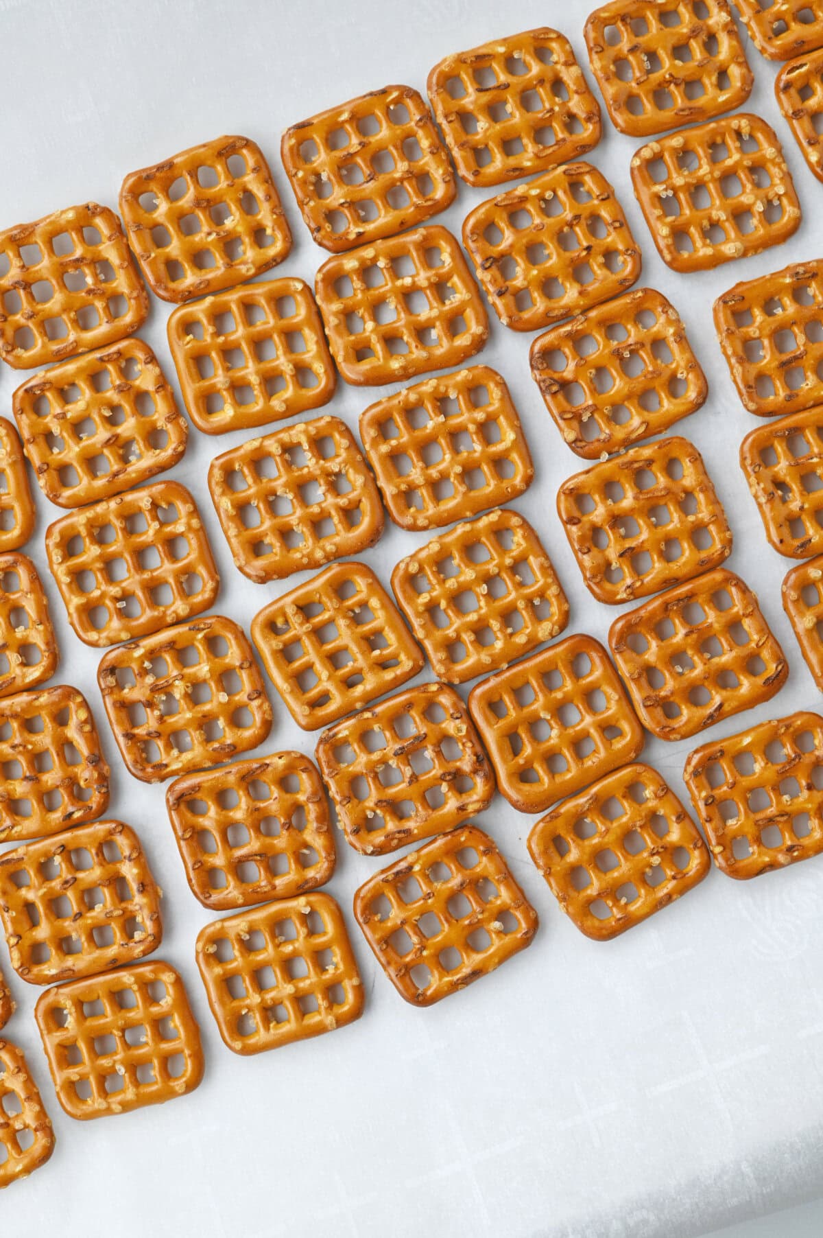 pretzels lined on a piece of parchment paper in a single layer.