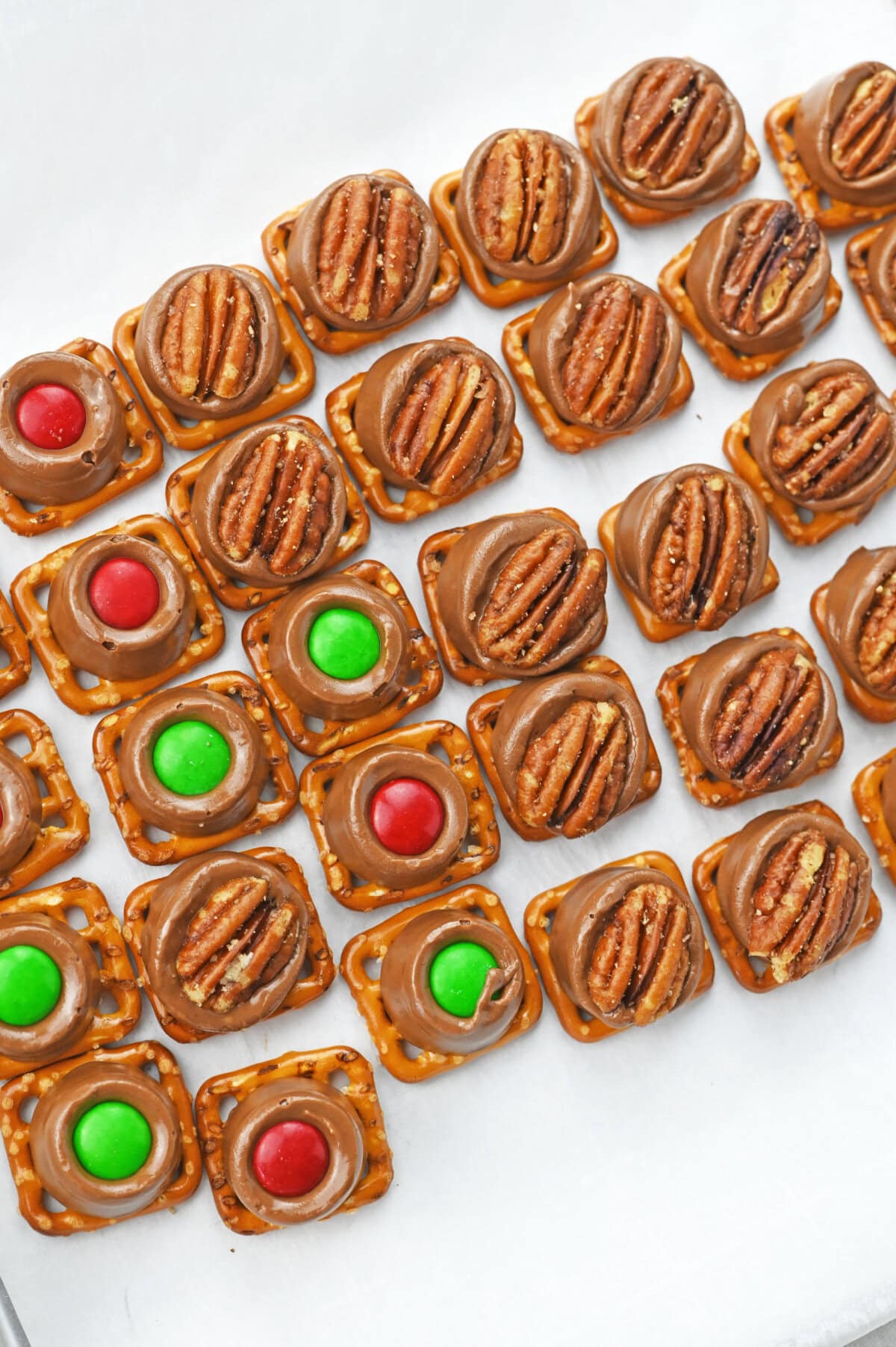 an m & m or pecan placed in the center of a melted rolo chocolate candy.