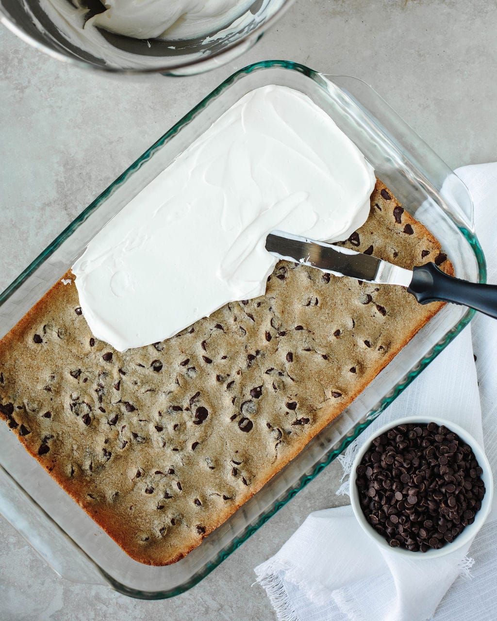 a cream cheese mixture spread on top of baked chocolate chip cookie dough.
