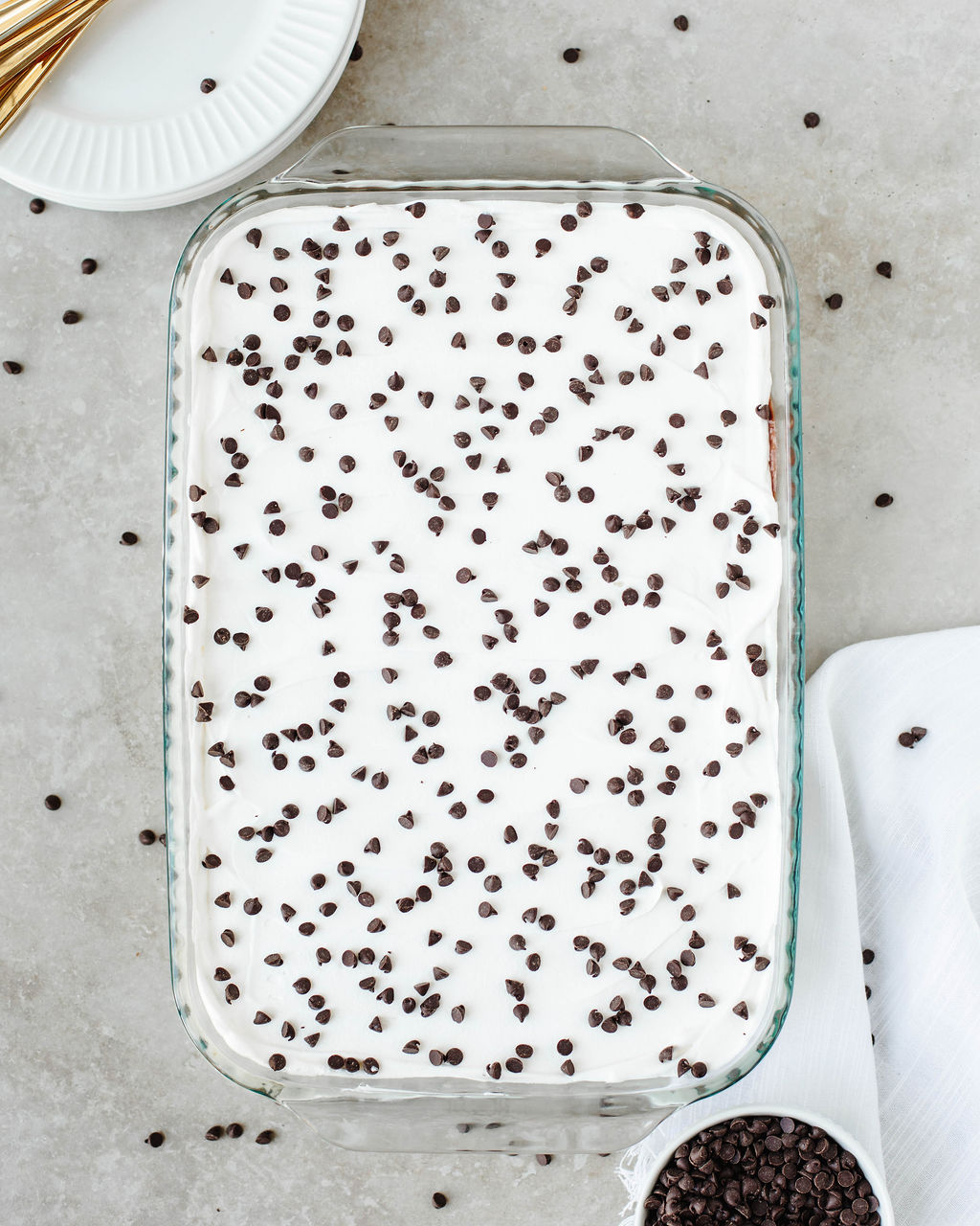 Chocolate chip cookie lasagna topped with whipped cream and chocolate chips