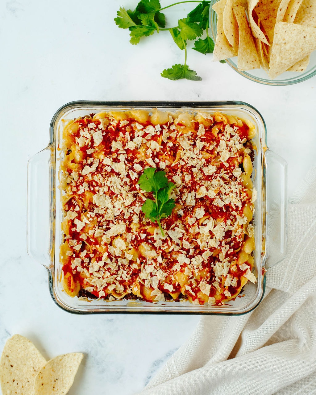 Layered beef nacho casserole topped with crushed tortilla chips, cheese, and jalapeños.