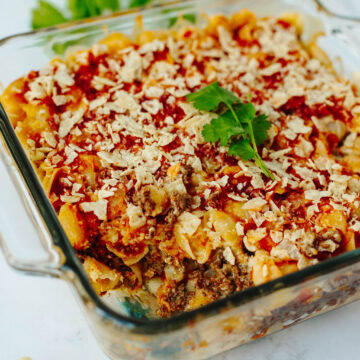cheesy velveeta nacho bake topped with crushed chips in a baking dish.