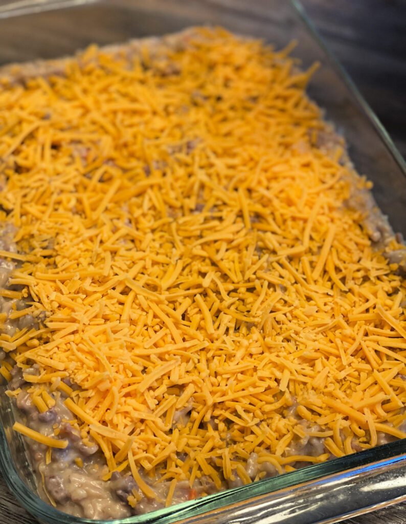 shredded cheese over cooked beef and rice
