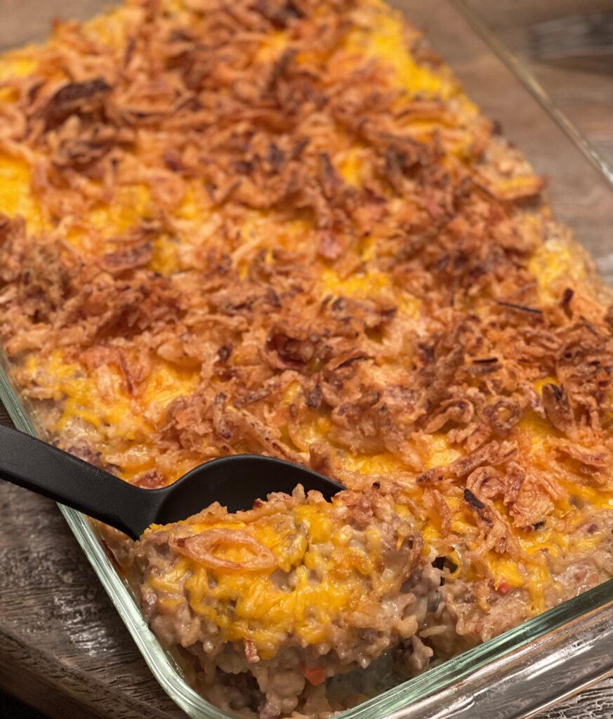 a scoop of casserole with ground beef, onions, cheese, and rice a roni