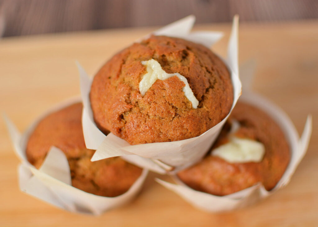an up close look at carrots cake muffins with cream cheese filling