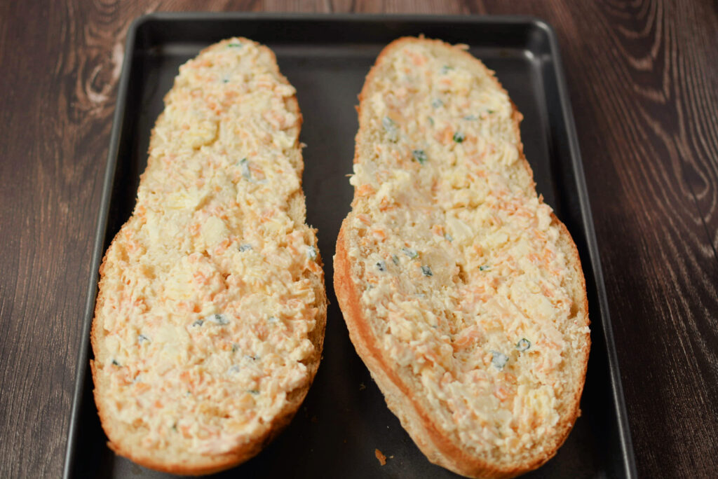 buttery, cheesy mixture spread evenly onto two french bread halves