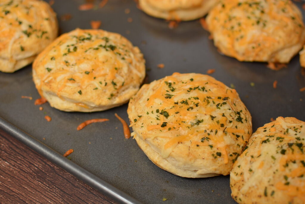 fluffy, cheddar biscuits on a cookie sheet