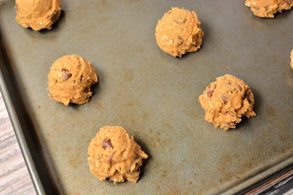 cookie dough scoops on a baking sheet