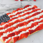 a Patriotic dessert pizza with fresh fruit in the shape of a flag.