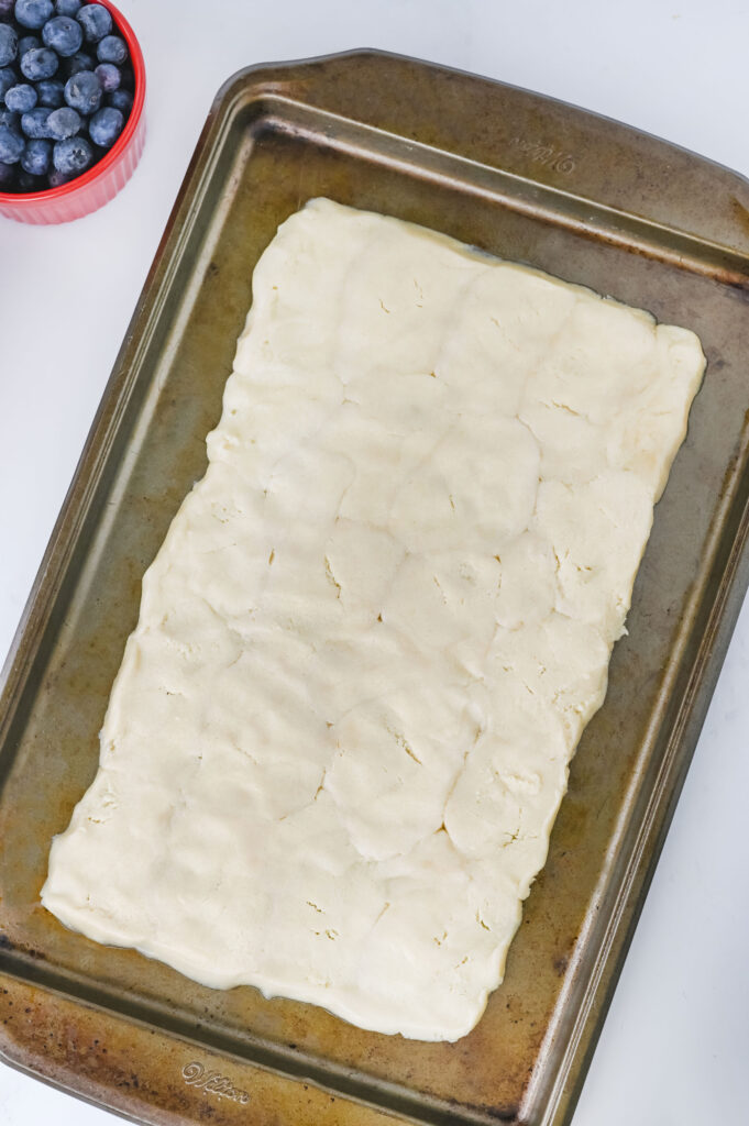 A massa de biscoito de açúcar de pillsbury foi lançada em uma assadeira.