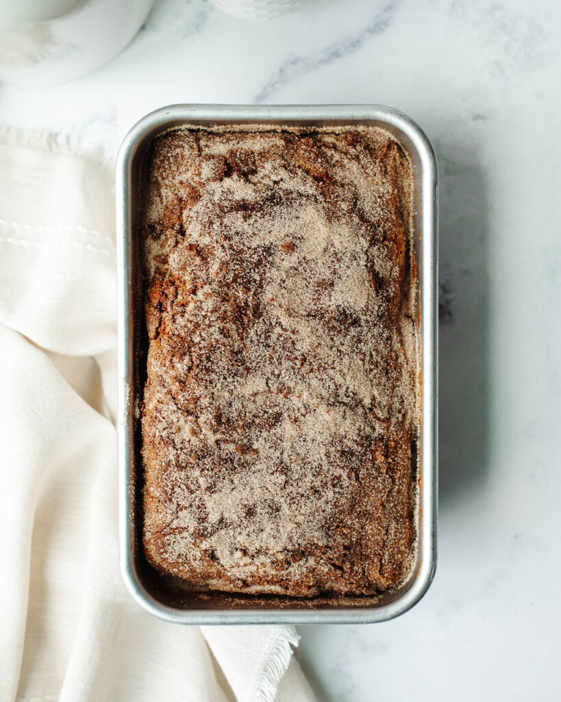 a baked loaf of quick bread with cinnamon sugar topping.