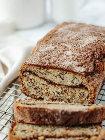 a loaf of snickerdoodle banana bread on a wire rack.