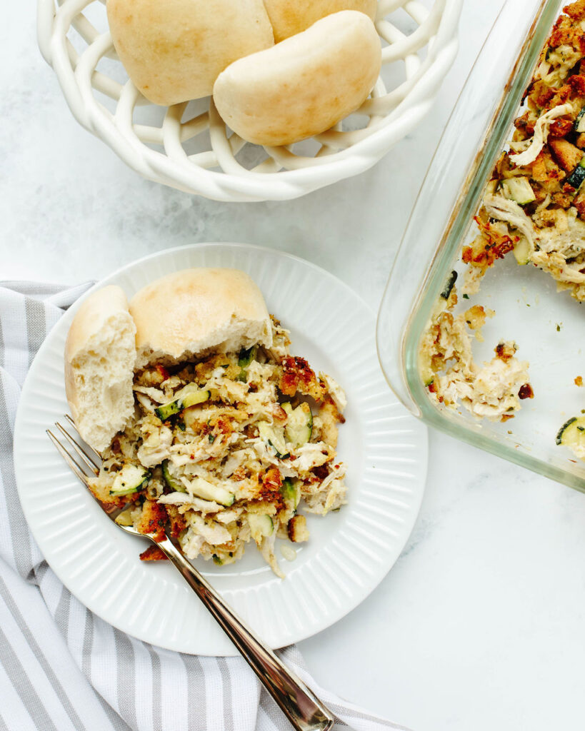 dinner rolls and hearty casserole on a white plate.