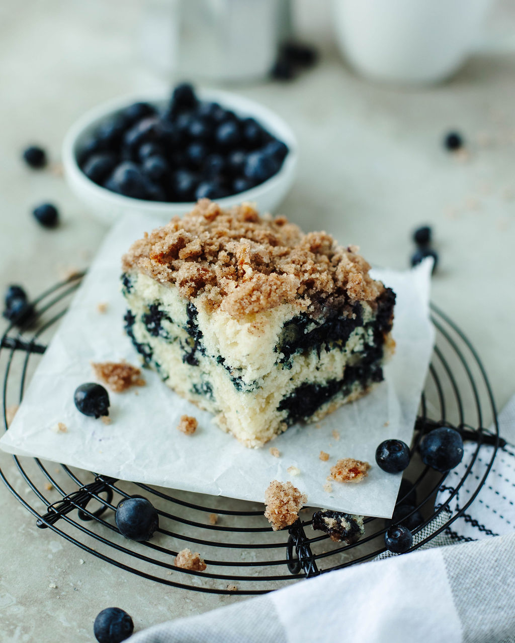 a slice of cake on a wire rack with fresh berries.