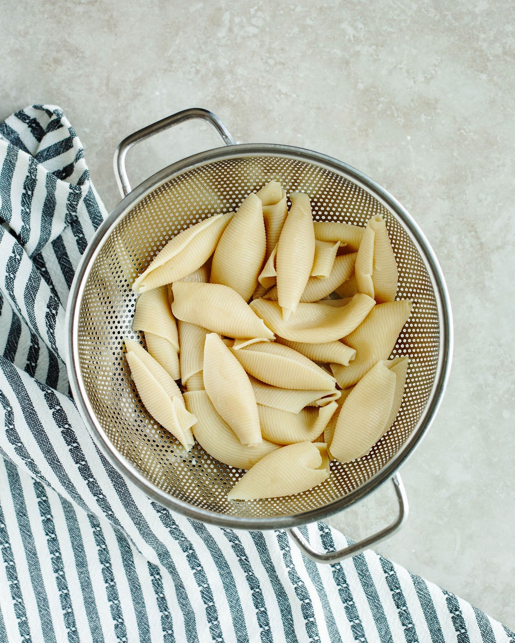 cooked jumbo pasta shells in a strainer.
