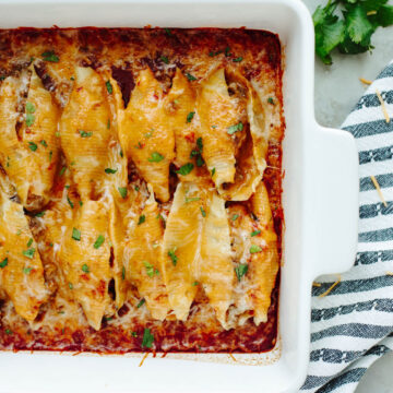 cheesy Mexican stuffed shells in a white baking dish.