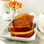 sliced pumpkin bread on a white serving platter.