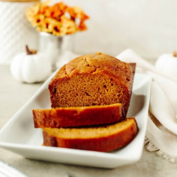 sliced pumpkin bread on a white serving platter.
