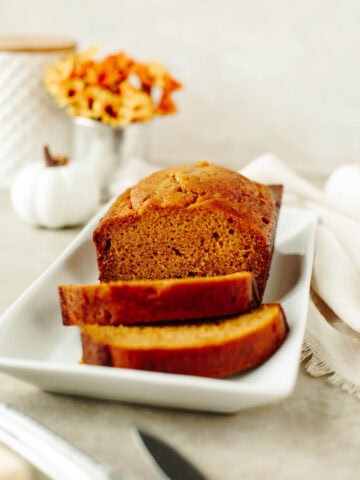 sliced pumpkin bread on a white serving platter.