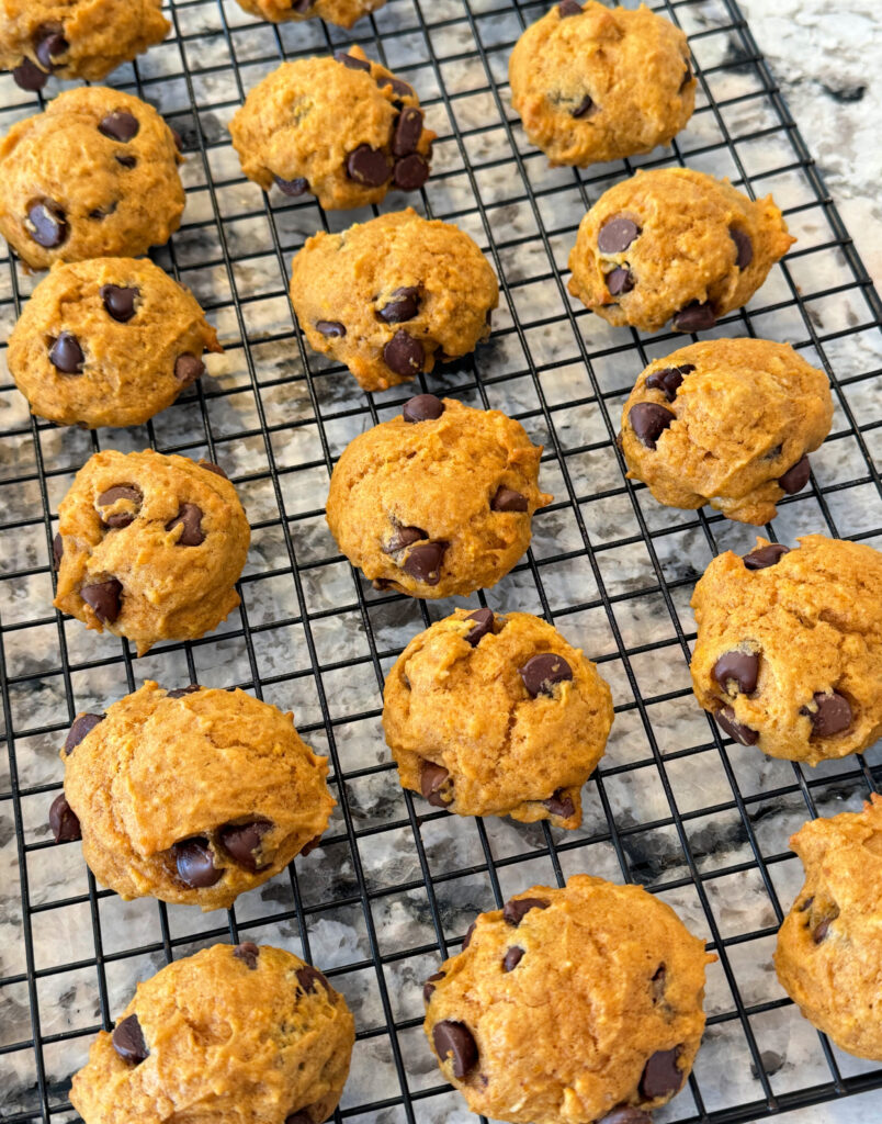 fresh baked pumpkin cookies lined up on a cooling rack.