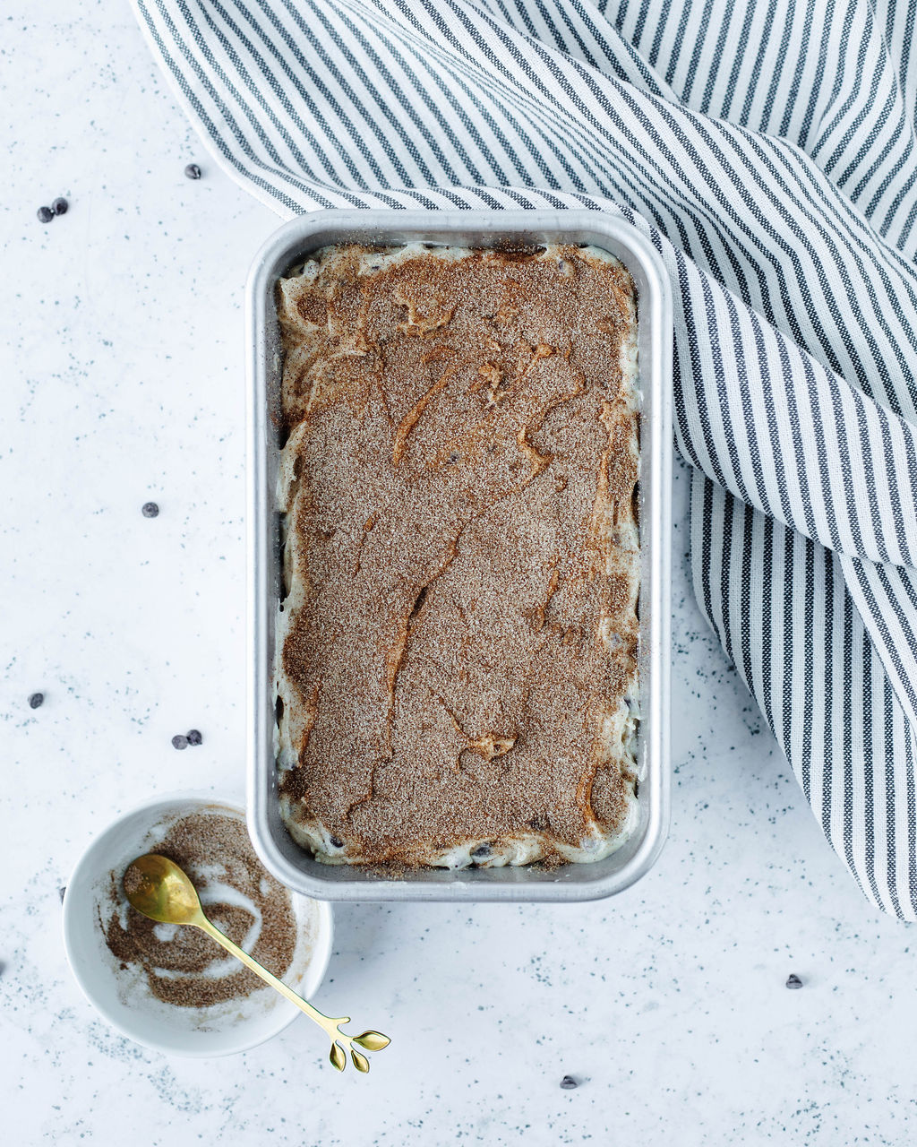 cinnamon sugar coating on top of quick bread batter in a loaf pan.
