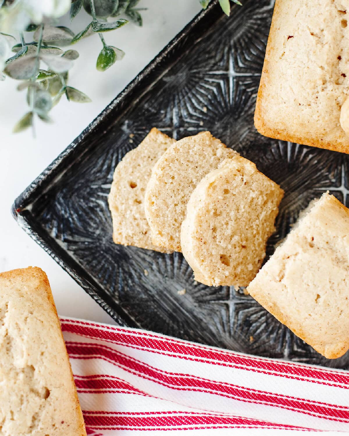 sliced eggnog quick bread on a black serving tray.