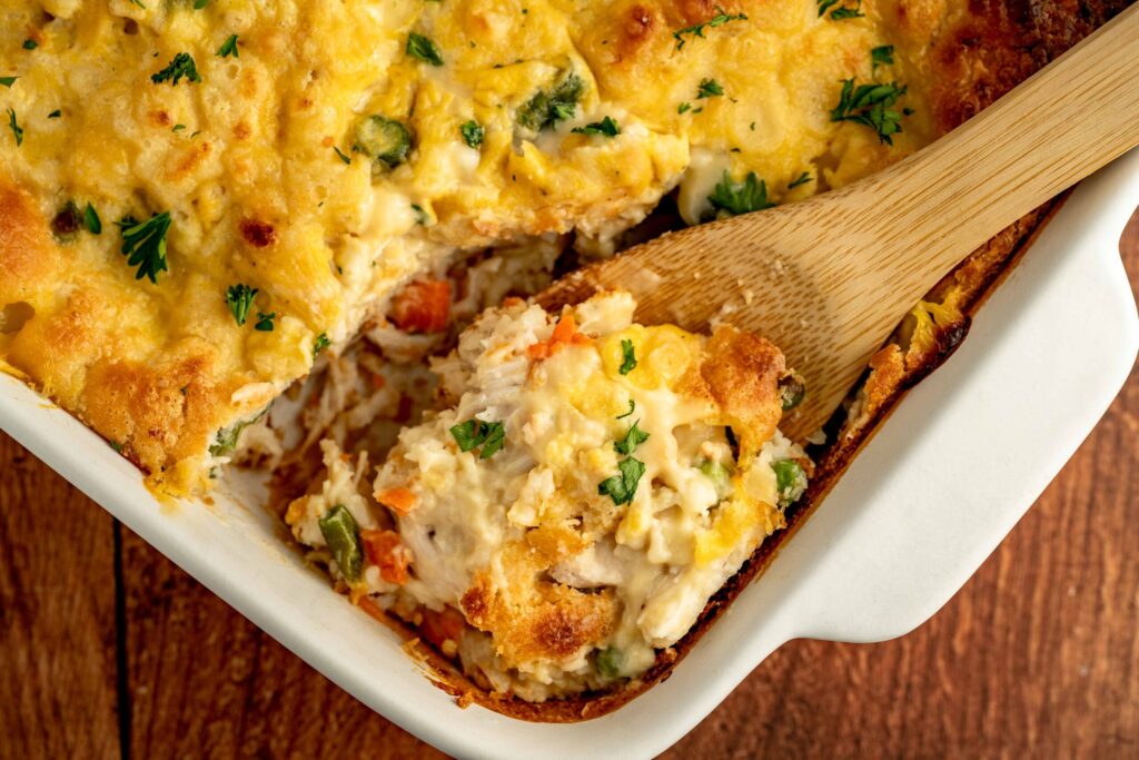 a scoop of chicken cobbler in a baking pan.