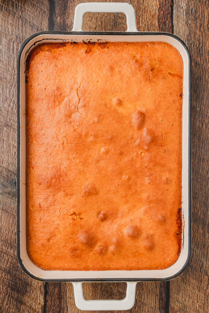 cornbread casserole baked in the oven and ready to slice into pieces.