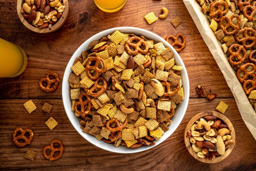 a mixture of chex cereal and pretzels coated in spicy seasonings.